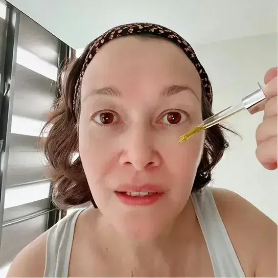Woman applying GloraMD Face Lift Serum near the eye area